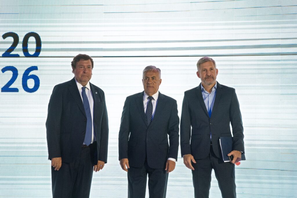 alt="Los gobernadores Weretilneck, Cornejo y Frigerio en el AmCham Summit 2026 debatiendo sobre nuevo acuerdo fiscal federal y desarrollo provincial"