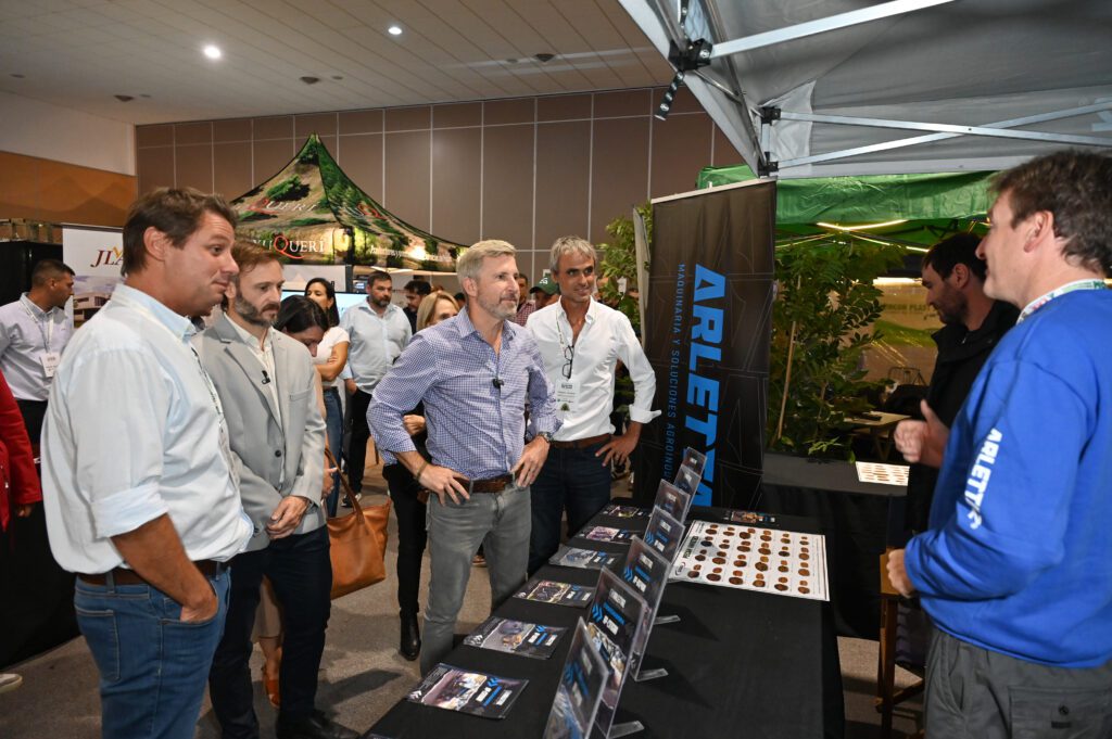 alt="diálogo entre Frigerio y expositores en un stand en el Centro de Convenciones de Concordia"