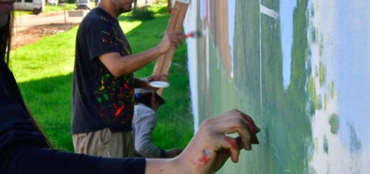 alt="Artistas pintando un mural al aire libre para el Encuentro Provincial de Muralismo en Maciá"