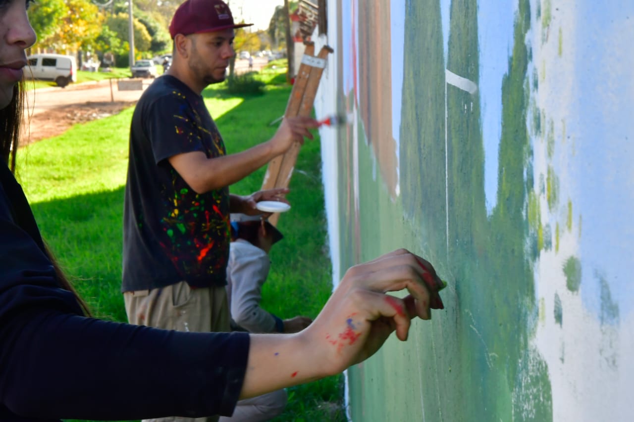 alt="Artistas pintando un mural al aire libre para el Encuentro Provincial de Muralismo en Maciá"