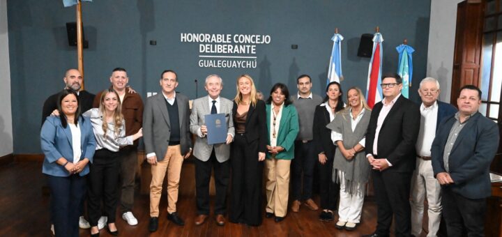 alt="Pipo Pescador en Gualeguaychú posando con concejales y autoridades locales en el recinto del Concejo Deliberante"