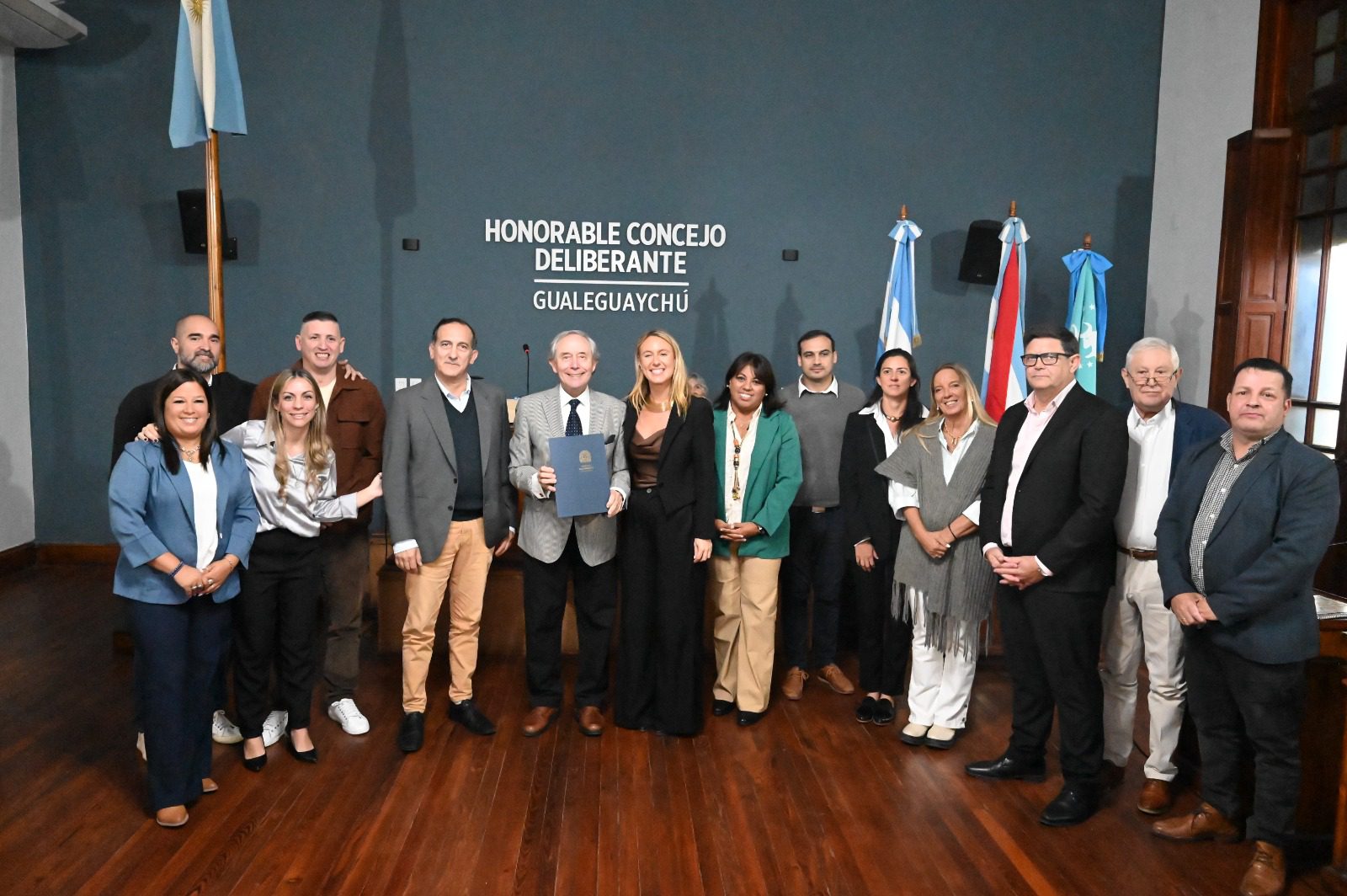 alt="Pipo Pescador en Gualeguaychú posando con concejales y autoridades locales en el recinto del Concejo Deliberante"