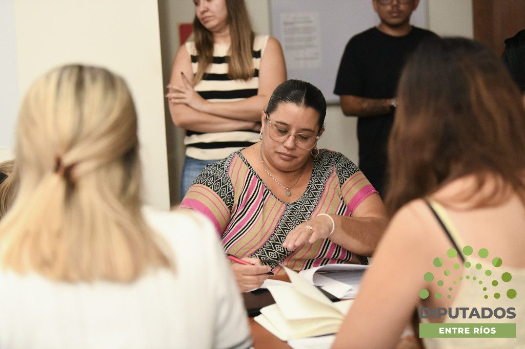 alt="Legisladora revisando documentos del protocolo contra a violencia laboral en la Cámara de Diputados de Entre Ríos en reunión de comisión"