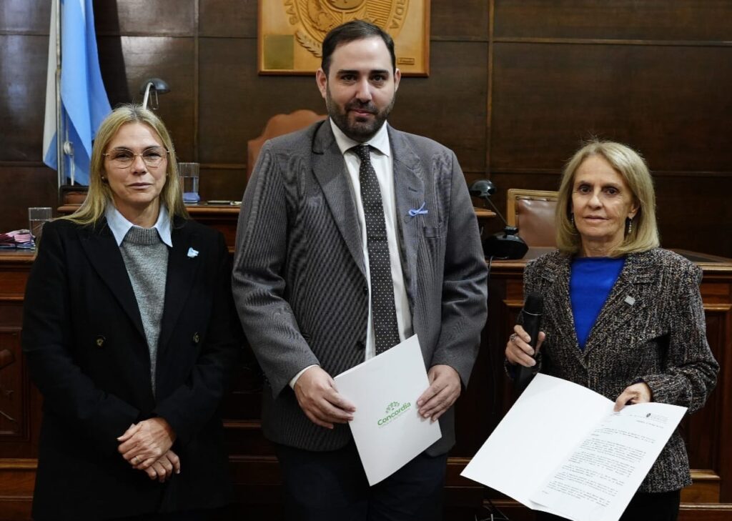 alot="Magdalena Reta de Urquiza, Marioi Matías Sebely y Verónica Del Boca posan con documentos oficiales en el Concejo Deliberante de Concordia"