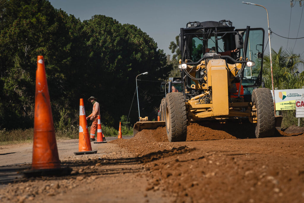 alt="Una motoniveladora amarilla empareja la tierra sobre la calzada en el marco de las obras de bacheo en la ruta 4 en Los Charrúas"