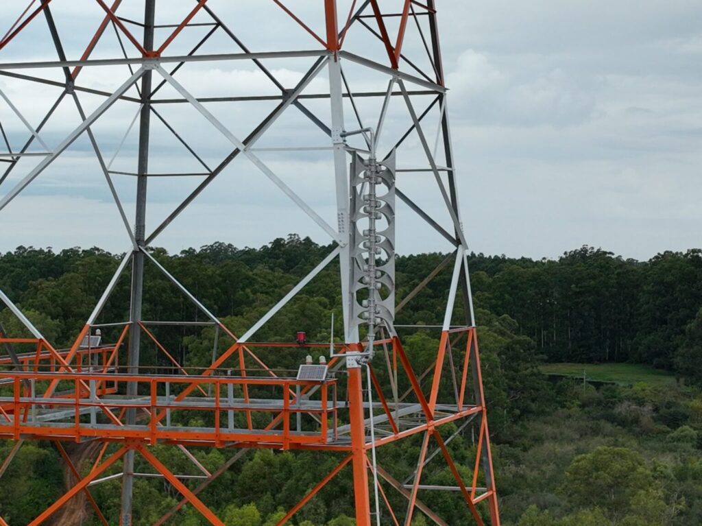 alt="Sirena del sistema de aviso sonoro para la gestión del riesgo hídrico en Salto Grande instalada en torre de alta tensión"