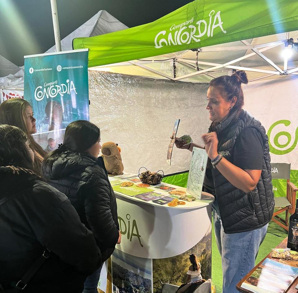 alt="Stand de información con personal atendiendo consultas sobre el turismo en Concordia"
