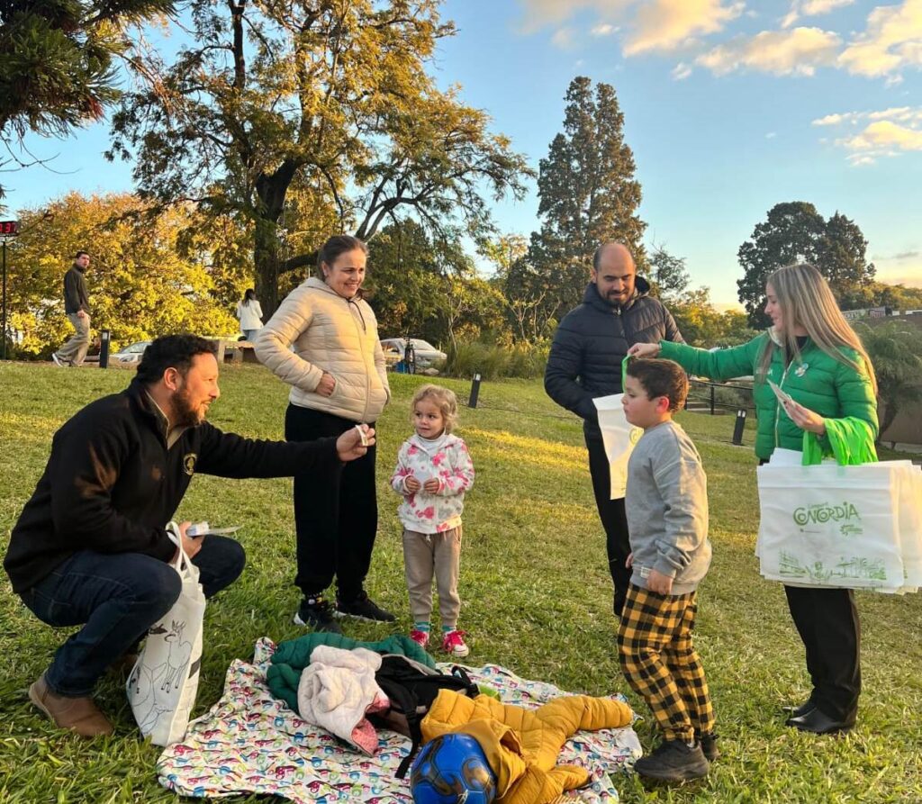 alt="Promotores turísticos entregan material a una familia en el parque San Carlos de Concordia en medio de una realidad marcada por las discrepancias sobre la ocupación hotelera en Concordia"