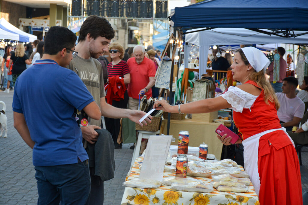 alt="Vendedora con vestimenta típica ofreciendo productos regionales a turistas durante el turismo en Entre Ríos por el Día del Trabajador"