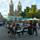 alt="Multitud recorriendo feria gastronómica y artesanal frente a una iglesia durante el turismo en Entre Ríos por el Día del Trabajador"