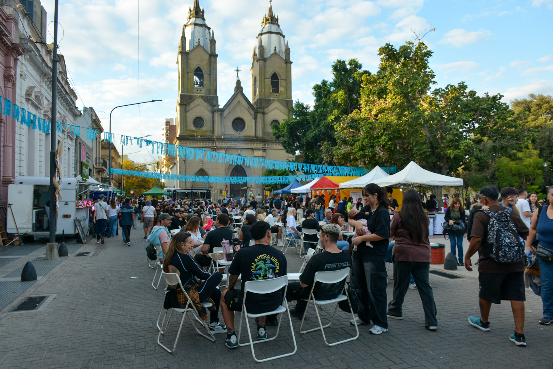 alt="Multitud recorriendo feria gastronómica y artesanal frente a una iglesia durante el turismo en Entre Ríos por el Día del Trabajador"