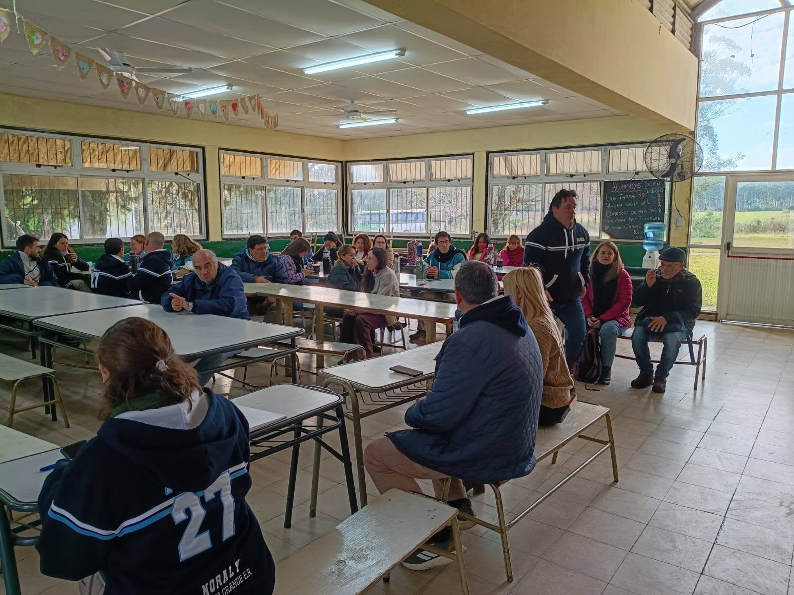 alt="Padres y docentes reunidos en una asamblea escolar debatiendo medidas ante la crisis en las escuelas de Concordia"
