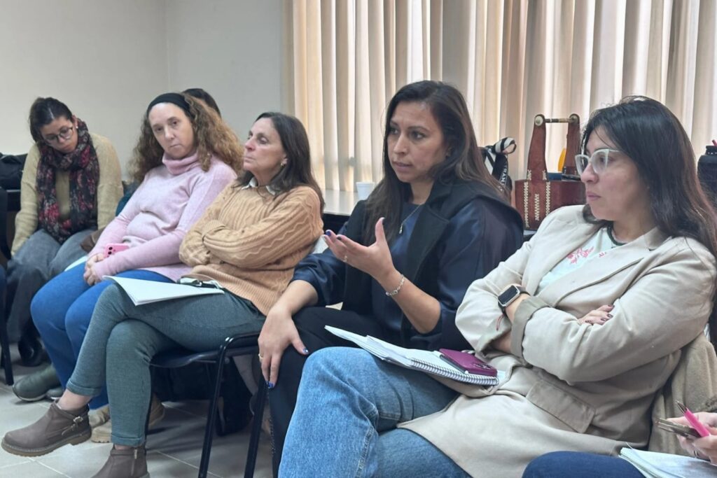 alt="Integrantes de los equipos de niñez en Concordia debaten activamente en un taller de trabajo sobre políticas territoriales"