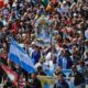 alt="Peregrinación y movilización religiosa con banderas, reflejando facetas de las tradicionales creencias de los argentinos"
