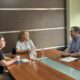 alt="Eduardo Cristina, Andrea Cottonaro y una colaboradora sentados alrededor de una mesa de madera dialogando antes de rubricar el convenio entre Codesal y la Dirección General de Estadística y Censos"