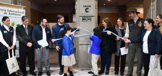 alt="Estudiantes de primaria cortan una cinta celeste y blanca acompañados por funcionarios en la inauguración de la Feria Eco Ciencias."