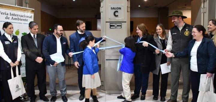 alt="Estudiantes de primaria cortan una cinta celeste y blanca acompañados por funcionarios en la inauguración de la Feria Eco Ciencias."