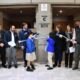 alt="Estudiantes de primaria cortan una cinta celeste y blanca acompañados por funcionarios en la inauguración de la Feria Eco Ciencias."