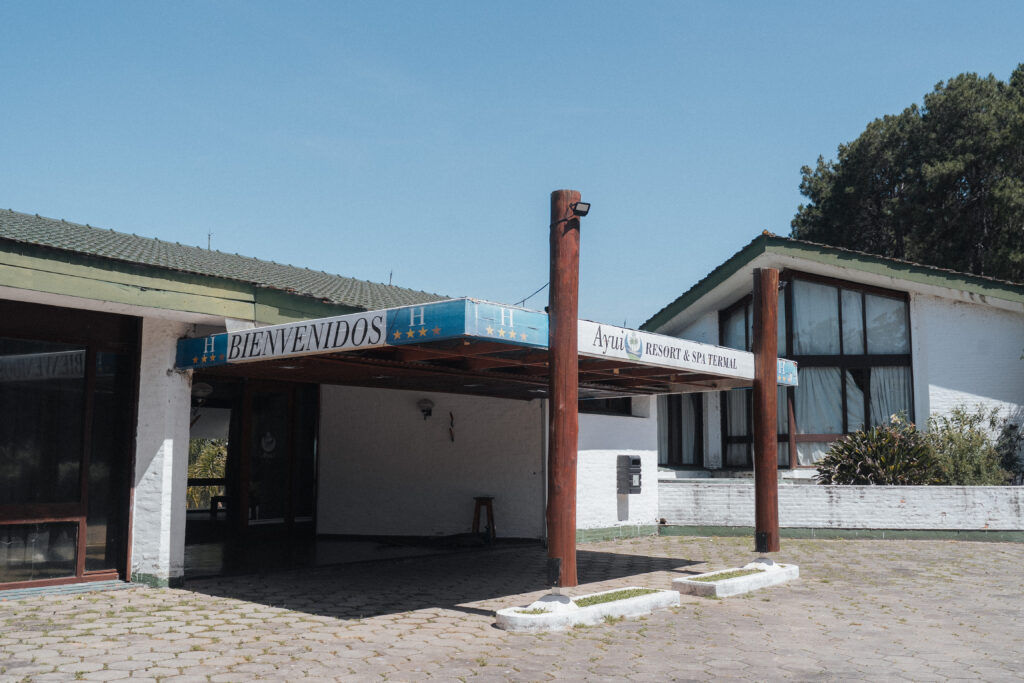 alt="Fachada de ingreso con cartel del complejo termal objeto de la licitación del Hotel Ayuí"