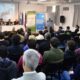 alt="Vista de sala llena en la apertura de las capacitaciones SIG-IDE en Concordia, con expositores y banderas institucionales"