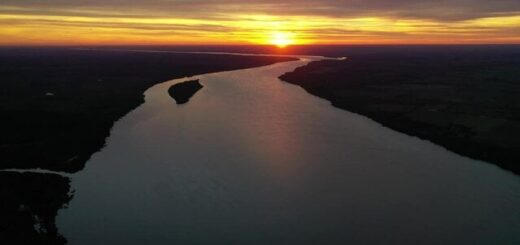 alt="Atardecer dorado sobre el curso de agua en alerta por la prevista crecida del río Uruguay"