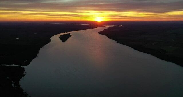 alt="Atardecer dorado sobre el curso de agua en alerta por la prevista crecida del río Uruguay"