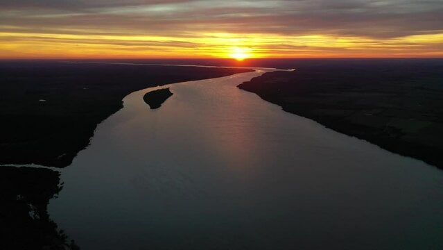 alt="Atardecer dorado sobre el curso de agua en alerta por la prevista crecida del río Uruguay"