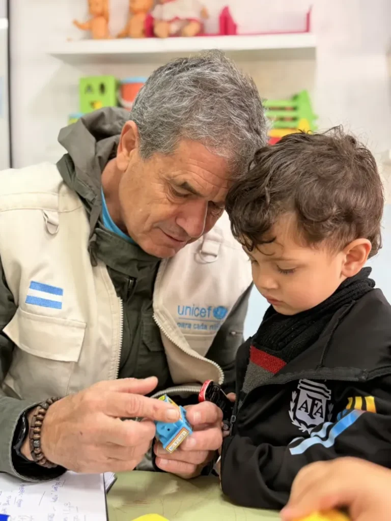 alt="Representante de la organización dialogando con un niño durante la evaluación de los desayunos de UNICEF en Entre Ríos"