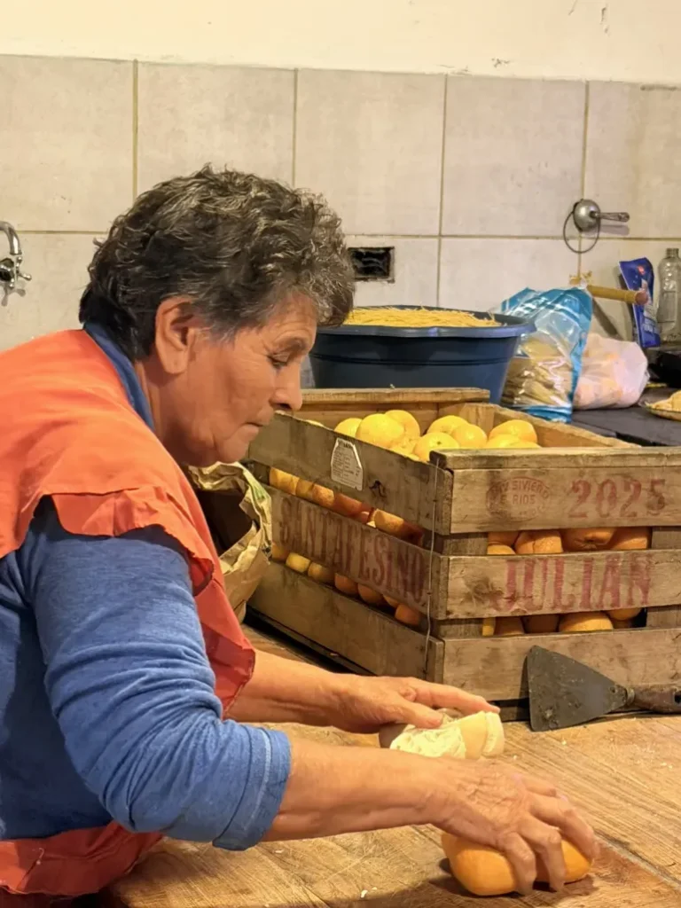 alt="Personal auxiliar preparando frutas destinadas a los desayunos de UNICEF en Entre Ríos dentro de una cocina comunitaria"
