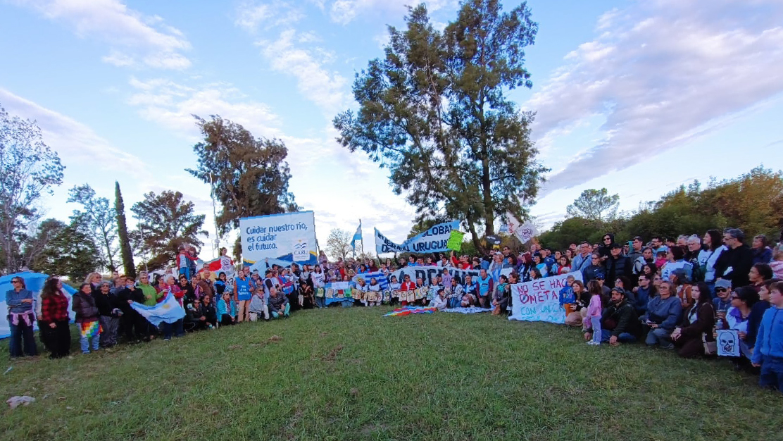 alt="Movilización contra la planta de hidrógeno verde en Paysandú, con manifestantes sosteniendo banderas y carteles en defensa del río Uruguay"
